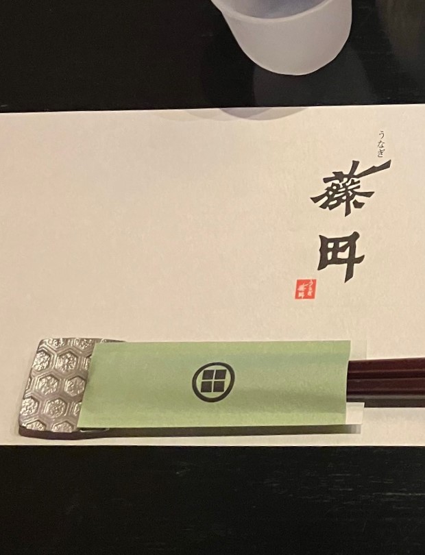 黒く塗られたテーブル、センスの良いテーブルマット、銀の箸置き